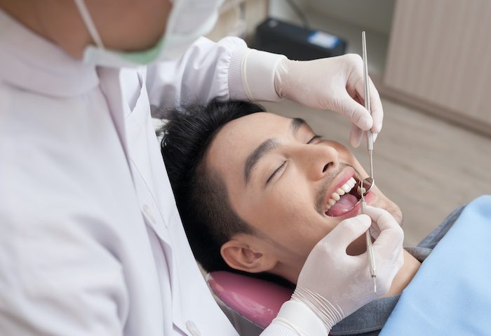 A man getting dental treatment in clinic with dentist. Dental care and healthy maintenance concept