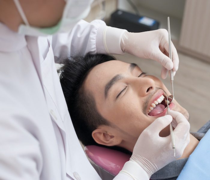 A man getting dental treatment in clinic with dentist. Dental care and healthy maintenance concept